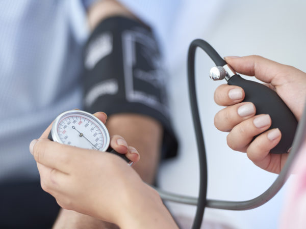 doctor taking patients blood pressure during annual physical